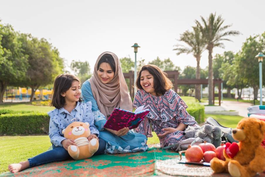 mother-is-sitting-at-park-with-her-children-in-nad-al-sheba-park